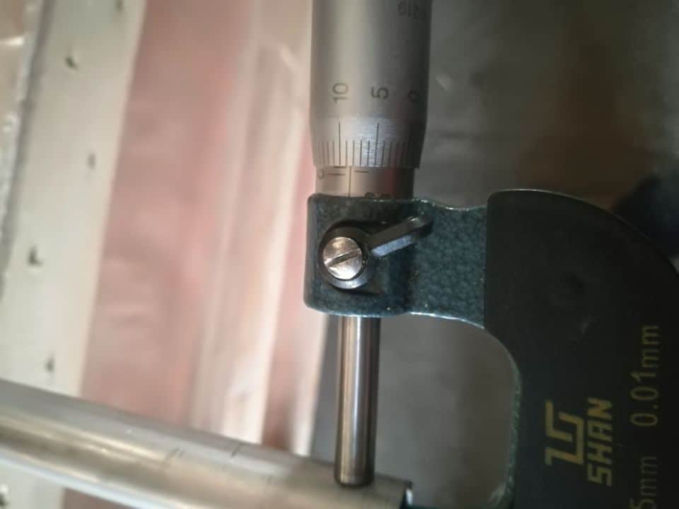 Micrometer measuring the wall thickness of a stainless steel tube during quality inspection